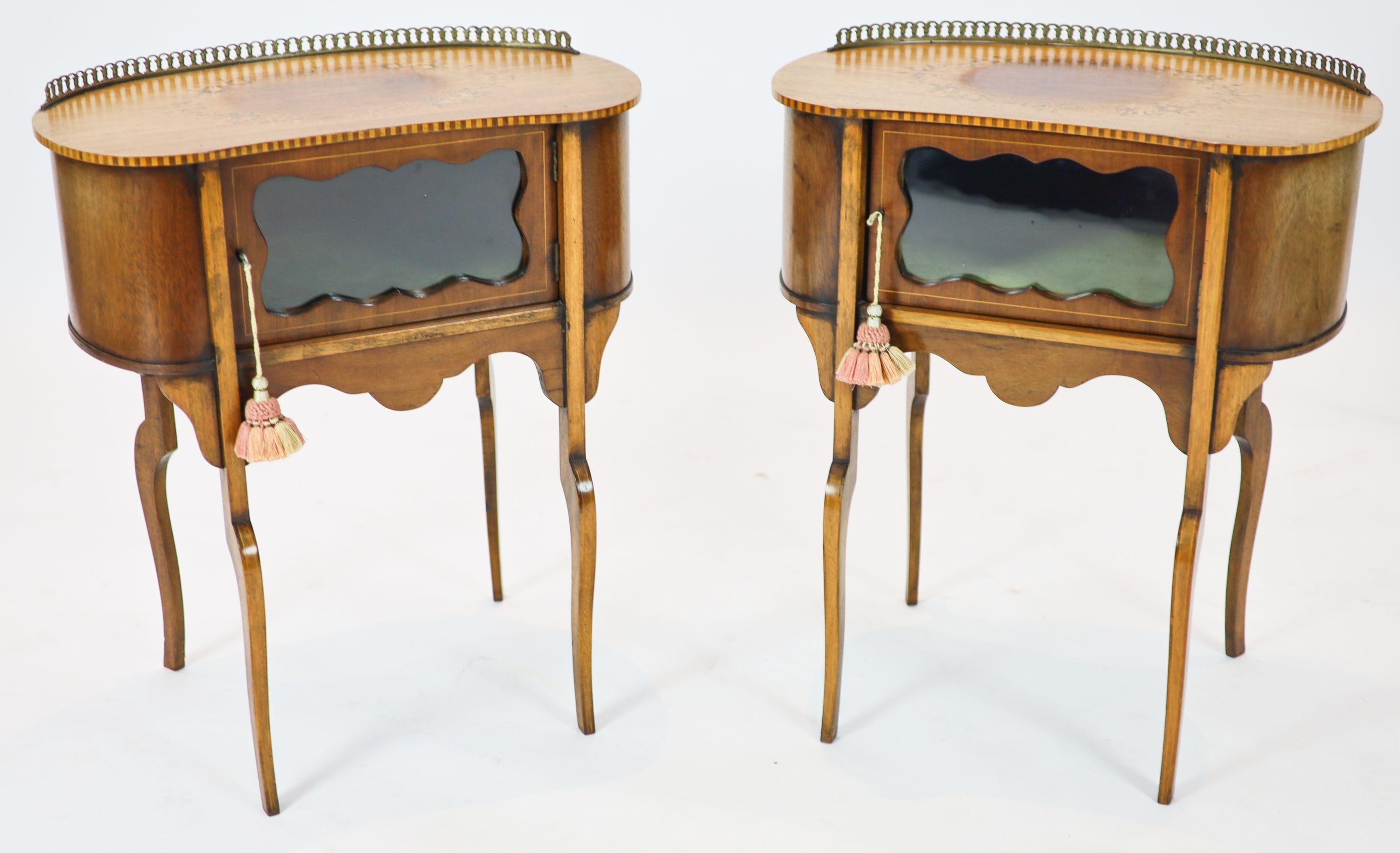 A pair of Edwardian inlaid mahogany kidney shaped side cabinets, each fitted with a central glazed door, raised on cabriole legs, width 60cm, depth 37cm, height 70cm